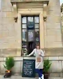 Claudia standing in front of the Claudia Coffee window in Prague
